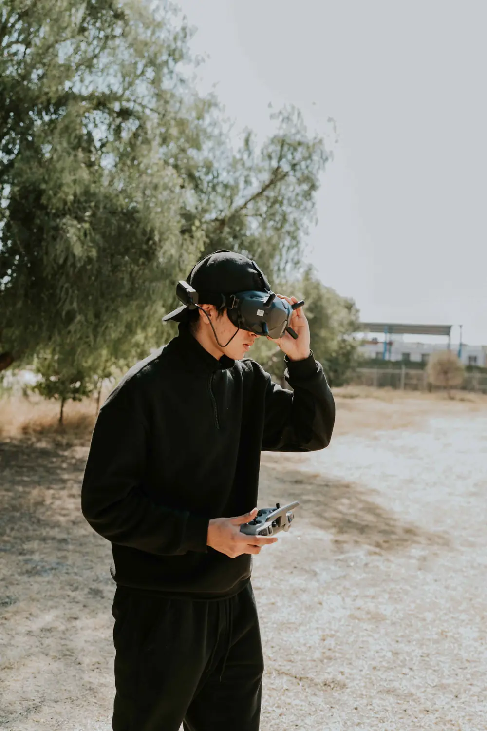 Drone pilot with FPV goggles on a beach (illustrative stock photo)