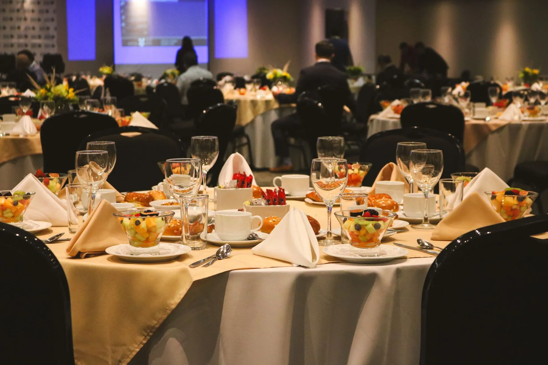 Conference banquet with round tables set before a keynote (illustrative stock photo)